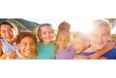 Helping Students Improve Their Social-Emotional Development and Function -Diverse group of children playing together in nature.