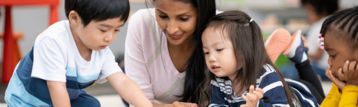 Preschool teacher reading with students