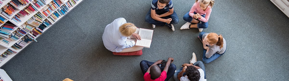 Teacher reading to young students 