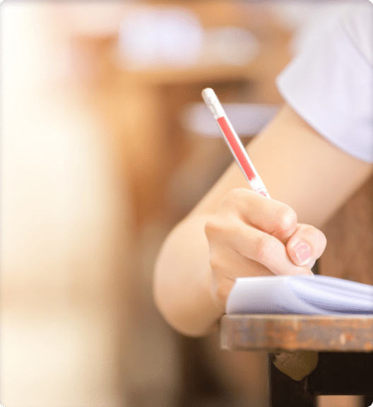 Student holding pencil writing on paper answer sheet