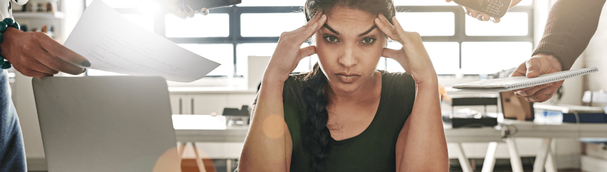 A woman at work dealing with sensory overload while trying to complete tasks.
